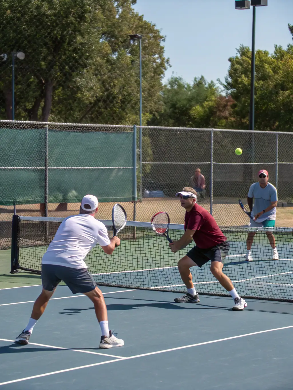 A group of adults participating in a doubles match on a clay court at TCR Tennis Club, enjoying a friendly and competitive game.